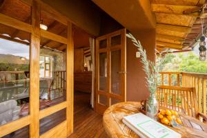 a wooden room with a table on a balcony at Unuwasi Hotel & Villa in Calca