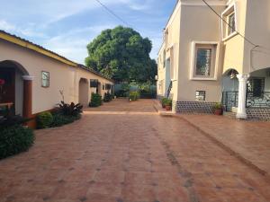 an empty brick road between two buildings at The Lamsarr Apartments in Tanji Manjago