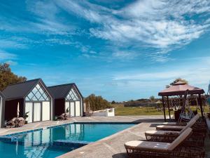 a villa with a swimming pool and lounge chairs at Yanis Resort in Calatagan