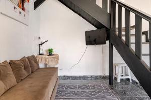 a living room with a couch and a tv at Beira-Mar Guest House in Arraial do Cabo
