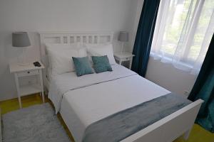 a bedroom with a white bed with blue pillows at Hrebet House Borovets in Borovets +57 photos