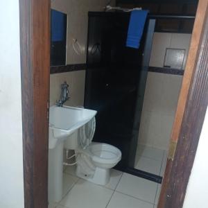 a bathroom with a toilet and a sink and a shower at Dona Maria - Quartos in Rio Grande da Serra