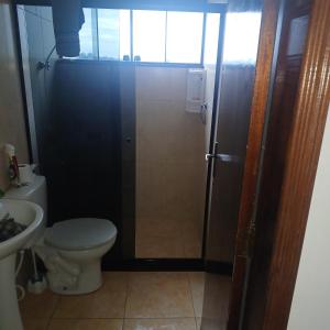 a bathroom with a shower with a toilet and a sink at Dona Maria - Quartos in Rio Grande da Serra