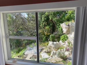 a window with a view of a rock garden at Limestone Studio in Whangarei