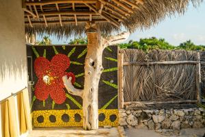 a rug with a flower on the side of a building at Sardine Beach Rote in Pulau Helihana