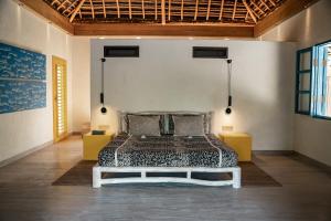 a bedroom with a bed in a room at Sardine Beach Rote in Pulau Helihana