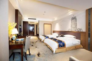 a hotel room with three beds and a desk and a desk at South Windmill Hotel in Zhengzhou