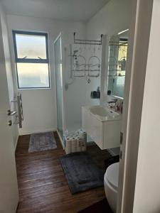a white bathroom with a sink and a toilet at Chriatcurrch Best Home in Christchurch +15 photos