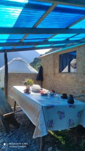 a blue tent with a table with a blue roof at Ernis Yurt Camp in Mineralʼnyy Istochnik Altyn-Arasan