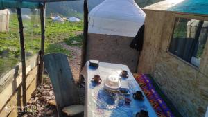 a table in front of a tent with a table sidx sidx sidx at Ernis Yurt Camp in Mineralʼnyy Istochnik Altyn-Arasan