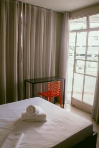 a bedroom with a bed with a chair and a window at kitnet no centro de Betim in Betim
