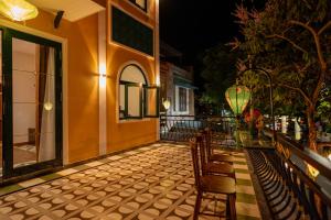 a balcony of a building with chairs and a table at De'Hoian Holiday Villa in Hoi An