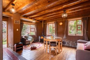 a living room with a table and some windows at Unuwasi Hotel & Villa in Calca
