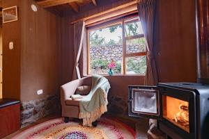 a living room with a chair and a fireplace at Unuwasi Hotel & Villa in Calca +231 photos