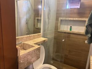 een badkamer met toilet en glazen douche bij 05 Kitnet próximo da praia com ar-condicionado in Maceió +41 foto's