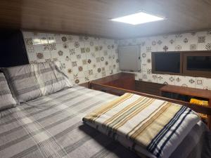 een slaapkamer met een bed en een tv aan de muur bij 05 Kitnet próximo da praia com ar-condicionado in Maceió