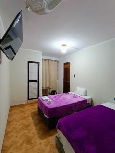 a bedroom with two beds and a flat screen tv at Hospedaje Live in Tingo María