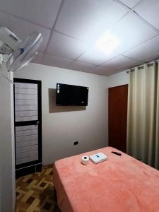 a room with a bed and a tv on the wall at Hospedaje Live in Tingo María