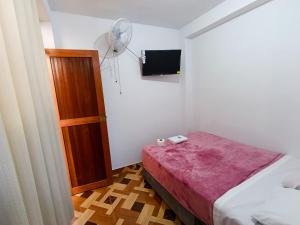 a small bedroom with a bed and a fan at Hospedaje Live in Tingo María