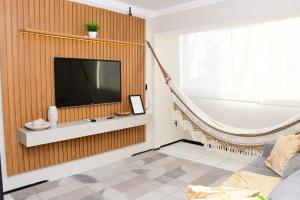 a living room with a television and a bath tub at Apartamento espaçoso e aconchegante in São Luís