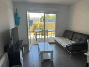 a living room with a couch and a table at Appartement Perpignan in Perpignan