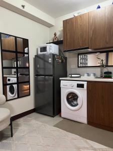 a kitchen with a refrigerator and a washing machine at Studio Condo in Saekyung Village One Phase3 in Lapu Lapu City