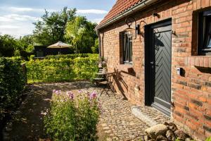 a brick building with a door and a bench next to a garden at Oasis Of Peace Near The Lake in Langen Jarchow +11 photos
