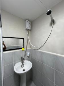 a bathroom with a white sink and a shower at Studio Condo in Saekyung Village One Phase3 in Lapu Lapu City +3 photos