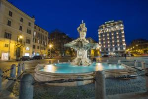 una fuente en medio de una ciudad por la noche en Hotel Modigliani en Roma