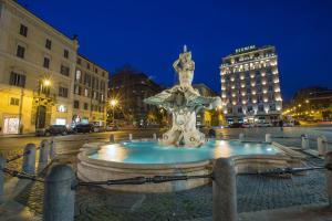 una fontana nel mezzo di una città di notte di Hotel Modigliani a Roma