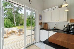 a kitchen with a sliding glass door leading to a deck at Cozy Summerhouse On Bornholm in Vester Sømarken