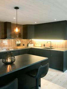 a kitchen with black cabinets and a table and chairs at Large Cabin Near Hardangervidda With Sunny Veranda in Veggli