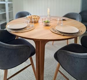 a wooden table with chairs and plates on it at Cottage Charm Near Lønstrup Lighthouse in Lønstrup