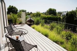 Una terraza de madera con dos sillas y una mesa. en Idyllic Vineyard Retreat Near Klingenmünster, en Klingenmünster