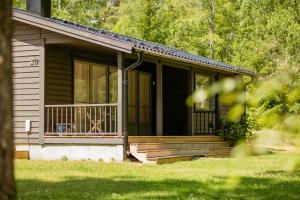 a small black house with a porch and a door at Bright, Airy, And Blissful Idyllic Holiday Home in Norrtälje