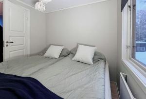 a small bedroom with a bed with two pillows at Bright, Airy, And Blissful Idyllic Holiday Home in Norrtälje