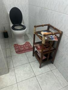 a bathroom with a toilet with a black lid at rent room papeete in Papeete