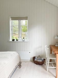 a bedroom with a bed and a desk and a window at Cozy Summer House Close To Bisnap Beach in Hals +26 photos