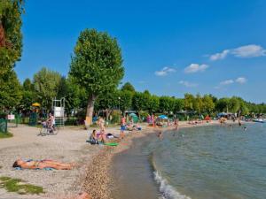 a group of people on a beach near the water at Apartment in Lazise with Lake View Balcony in Lazise
