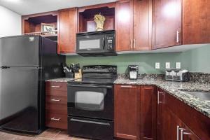 a kitchen with black appliances and wooden cabinets at Cozy Retreat 2BR Condo with Jacuzzi & Indoor Pool in Pigeon Forge