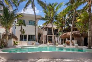 a swimming pool in front of a house with palm trees at New 3BR Private Beachfront Villa with Pool at Soliman in Tulum