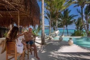 a man and a woman sitting in chairs on the beach at New 3BR Private Beachfront Villa with Pool at Soliman in Tulum