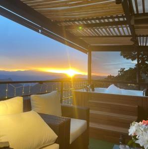 a balcony with a bed and a tub with the sunset at Kcafe Ancestral Glamping in Venecia