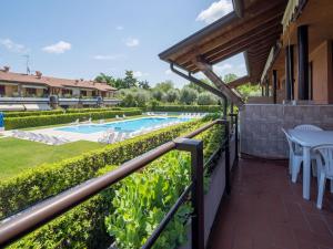 balcone con piscina, tavolo e sedie di Amazing holiday home in Lazise with swimming pool a Lazise