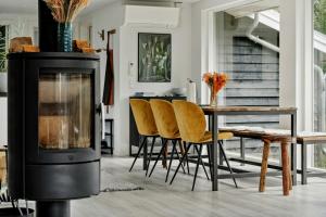 a living room with a wood stove and a table at Beautiful Tranquil Home By Fjord Near Copenhagen in Holbæk +27 photos