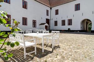 a white table and chairs in front of a building at Unique Stay At Odden Manor & Museum in Hjørring