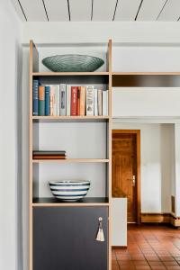 a shelf with books and a bowl on it at Tradition Meets Modern In Gulf House in Ostermarsch