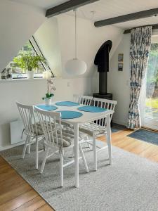 a dining room with a white table and chairs at Summerhouse By The North Sea in Vestervig