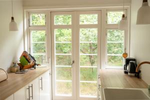 a kitchen with a large window and a sink at Red Stone House By Dueodde Beach in Neksø