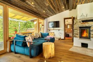 a living room with a blue couch and a fireplace at Cabin In The Nature Of Bavaria in Schöllnach
